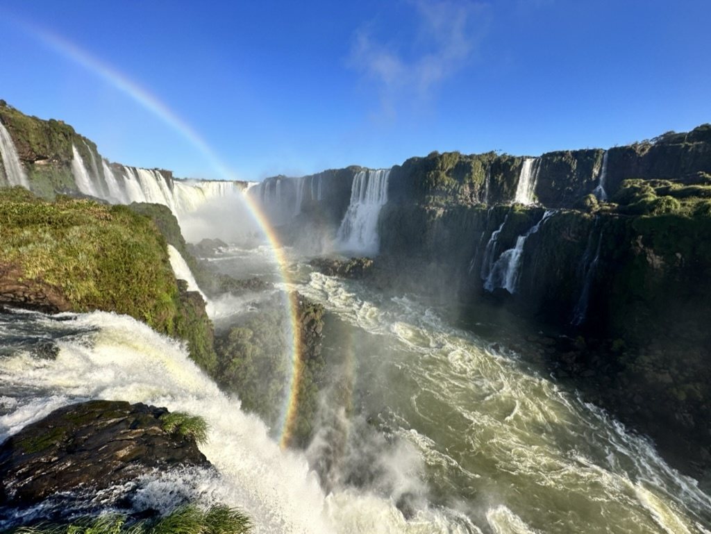 Iguazu Falls with a rainbow rising through the mist
